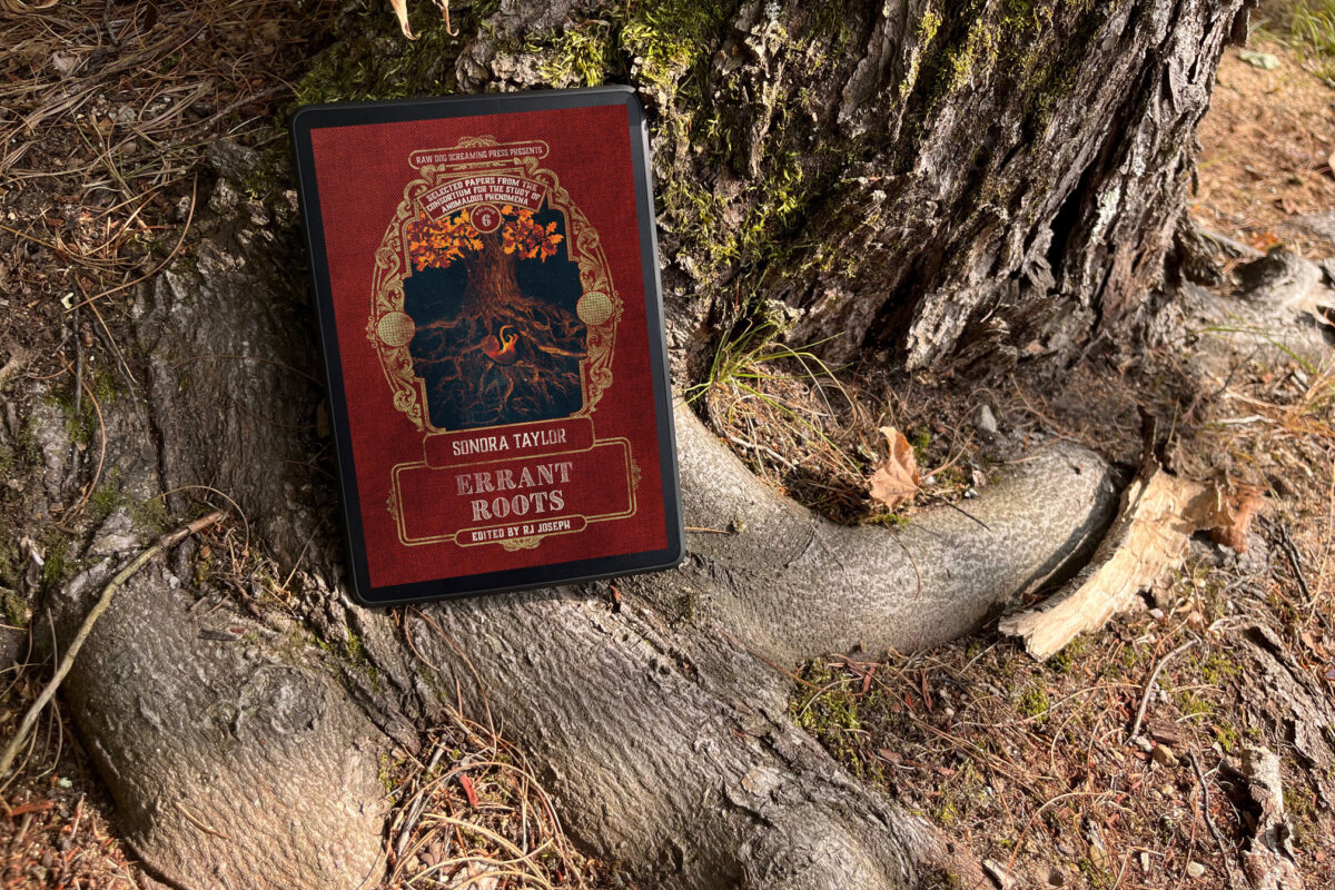 Errant Roots by Sonora Taylor | Book Review and Book Photo by Erica Robyn Reads - features kindle sitting on tree roots with book cover of a fetus nestled within tree roots