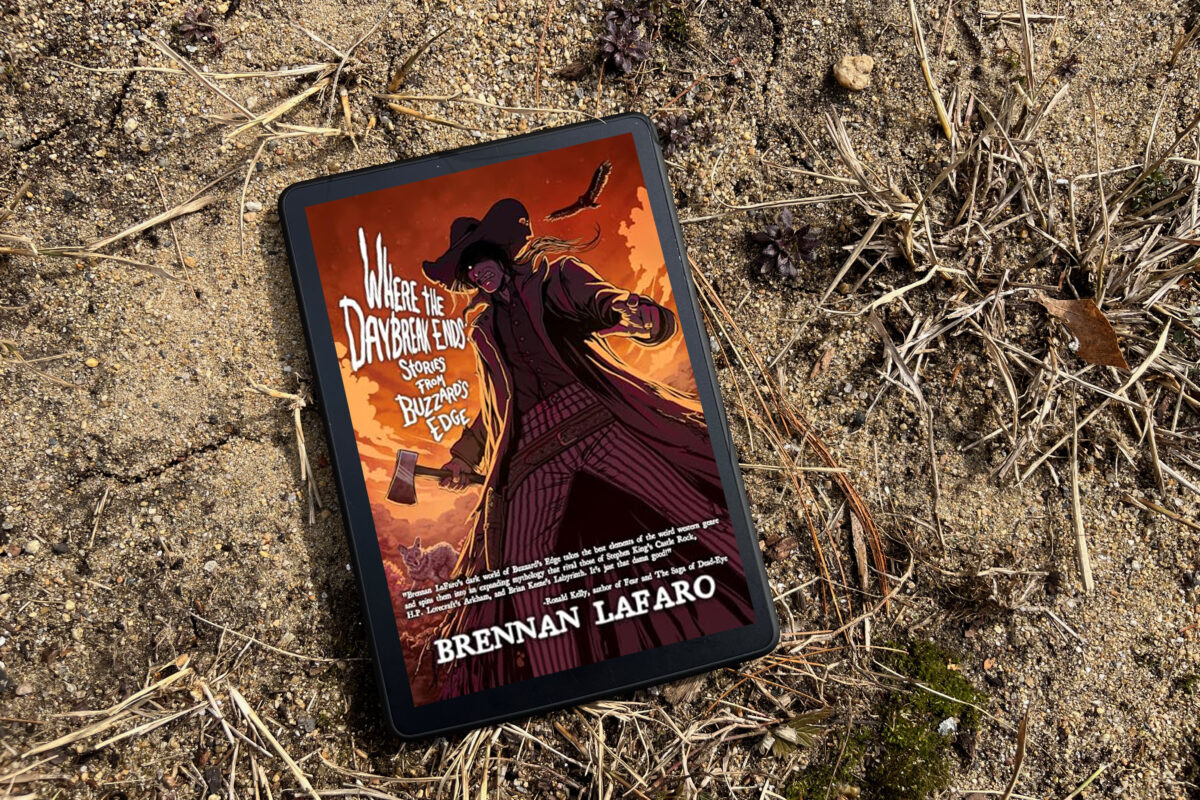 Where the Daybreak Ends: Stories from Buzzard's Edge by Brennan LaFaro | Book Photo features a sandy backdrop with western horror illustration on the book cover